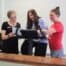 Three women focusing on accountability in front of a counter.
