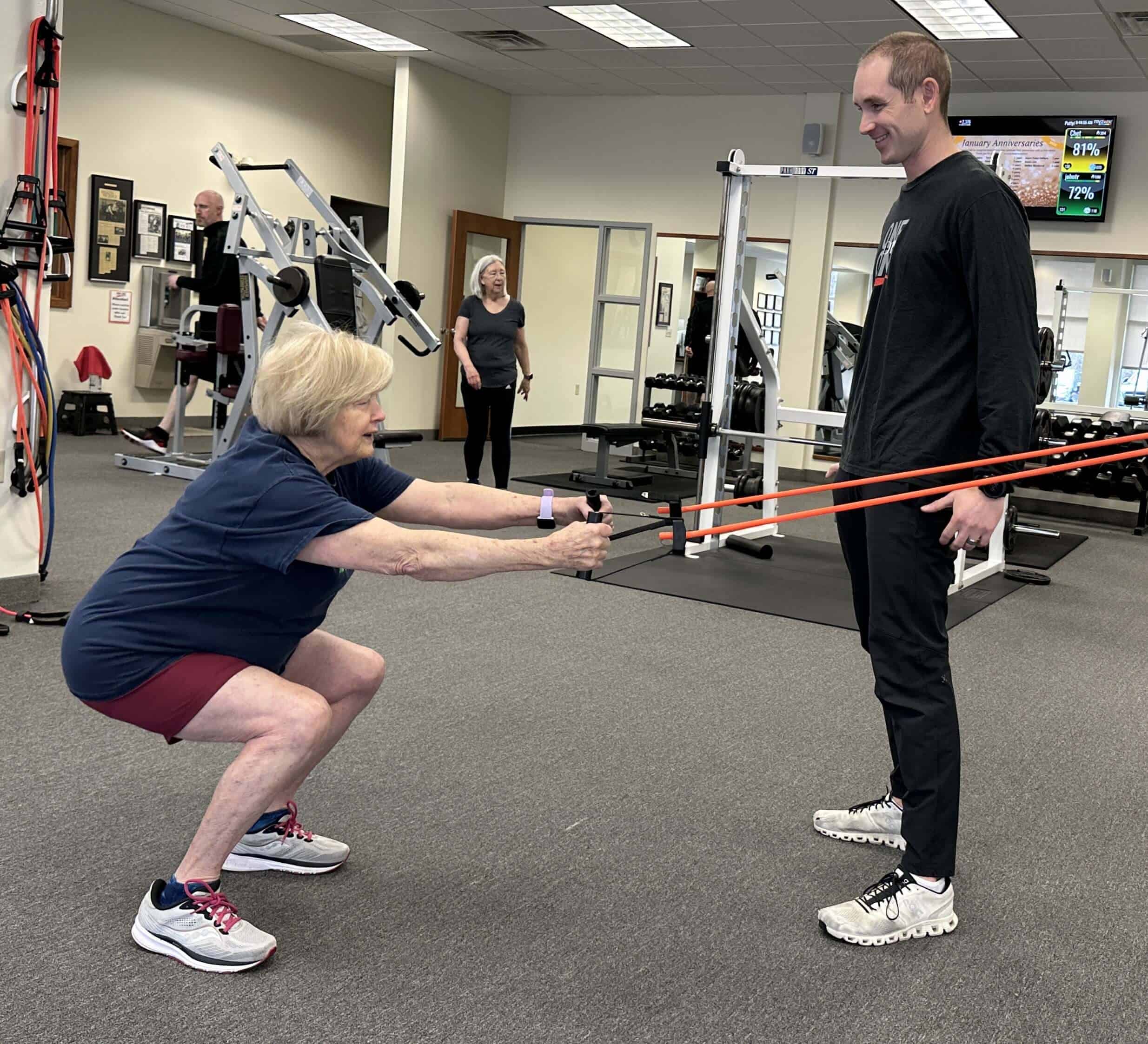 Client performing an assisted squat during her personal training session