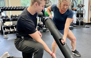 Client performing Vipr Shovel with trainer cuing