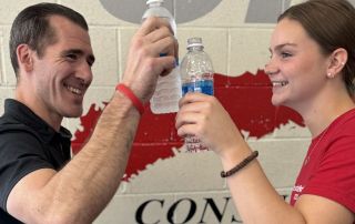 Energetic gym trainers celebrating after one-on-one fitness training session.