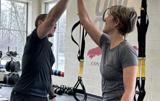 High-energy personal training session at One on One Fitness with a trainer giving a high five.